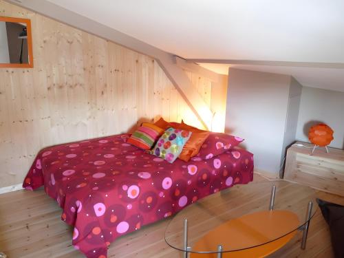 a bedroom with a pink bed with a glass table at Maison Ô'5 Avec Terrasse in Lanton