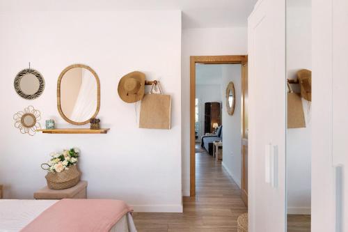 a bedroom with white walls and a hallway with mirrors at Villa Tino- Casa M in Los Llanos de Aridane