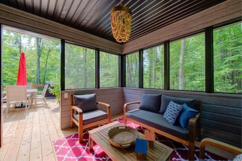 a screened in porch with a couch and chairs at La Mi-Temps Spa - Relaxation & Private Spa in Pont-Rouge