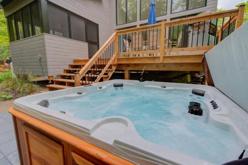 a hot tub on a deck next to a house at La Mi-Temps Spa - Relaxation & Private Spa in Pont-Rouge