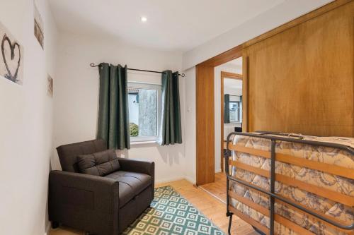 a bedroom with a bed and a chair and a window at Ferienwohnung Weyres in Fleckeby
