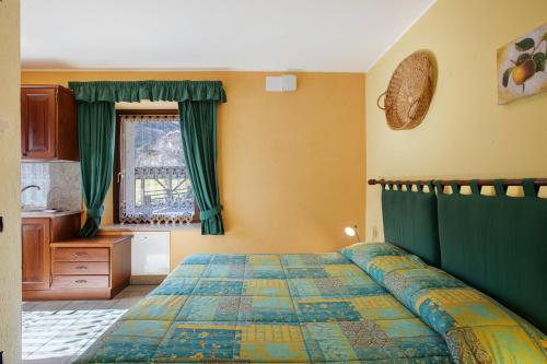 a bedroom with a bed with green curtains and a window at Verger Plein Soleil di Piero in Saint-Pierre