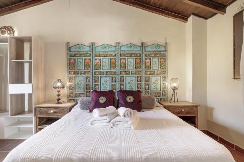 a bedroom with a large bed with towels on it at El Puente Ronda in Ronda