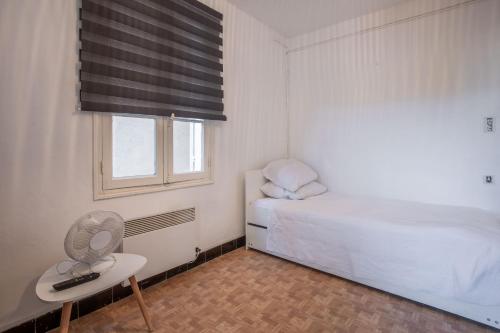a small bedroom with a bed and a window at Chez Lina - studio avec terrasse in Le Lavandou