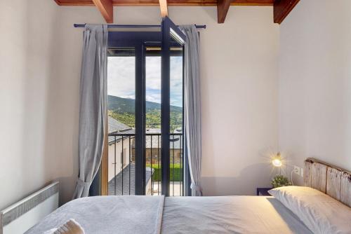 a bedroom with a bed and a large window at Apto Ideal En Osseja in Osséja