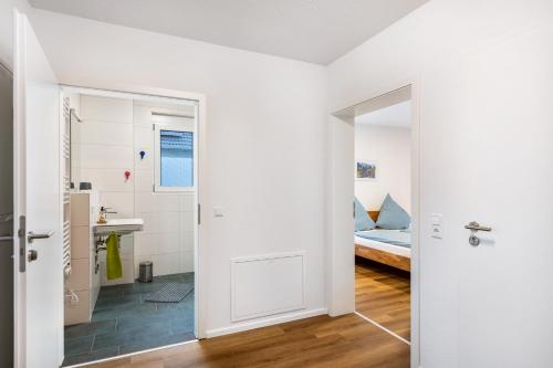 a white room with a bed and a bathroom at Ferienwohnung Vogesenpanorama in Bad Bellingen