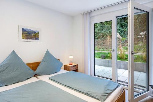 a bedroom with a bed and a large window at Ferienwohnung Vogesenpanorama in Bad Bellingen