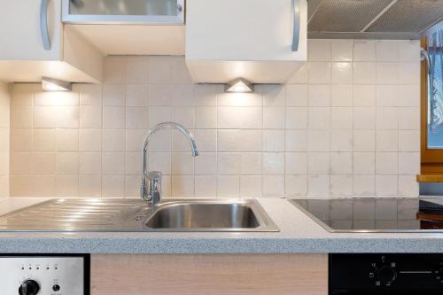 a stainless steel sink in a kitchen with white tiles at Apartment Weber in Nova Levante