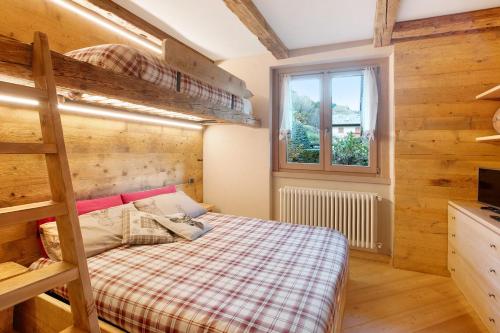 a bedroom with a bunk bed and a window at Casa Clus Bormio apartments 1 in Valdisotto