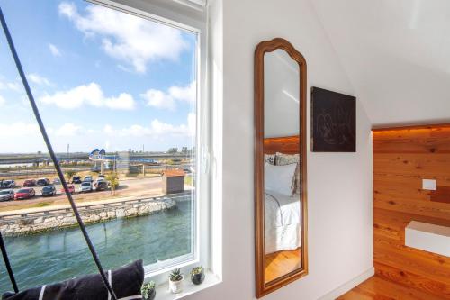 a bedroom with a window with a view of the water at Salina Ria Studio in Aveiro