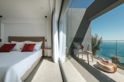 a bedroom with a bed and a large window at River Villas Plomari - Luxury Villas with Direct Pool Access in Plomari