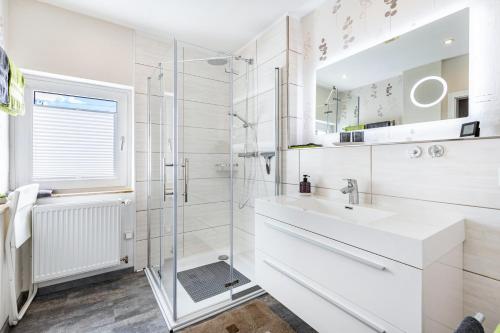 a white bathroom with a sink and a shower at Fewo Mama Mia in Menden