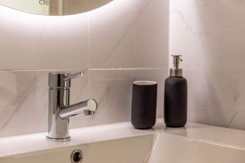 a bathroom sink with a black soap dispenser on it at Casa Homem do Mar in Paul do Mar
