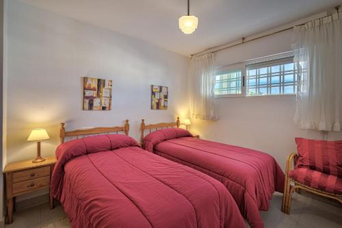 two beds in a bedroom with red blankets at Costa Bella in Altea