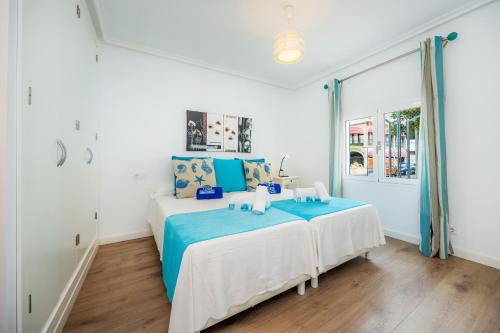 a bedroom with a bed with blue and white sheets at La Casita in Pollença