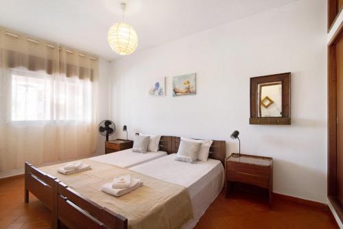 a bedroom with a bed and a mirror at Cabanas Mar 94 in Cabanas de Tavira