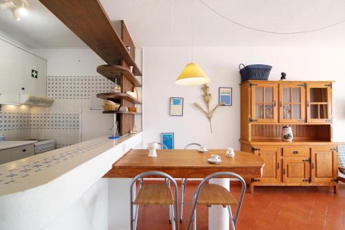 a kitchen with a wooden table and some chairs at Cabanas Mar 94 in Cabanas de Tavira