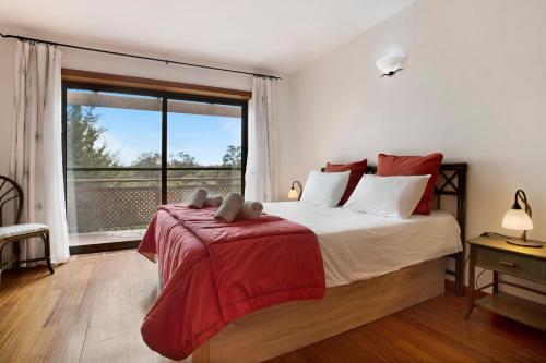 a bedroom with a large bed with a large window at Arrancada 7 in São Lourenço