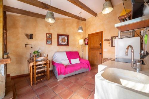 a kitchen with a pink couch and a table at El Mirador in Laroya