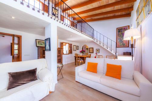 a living room with a white couch and orange pillows at Can Me Sents in Pollença