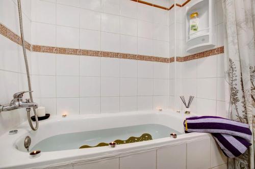 a bath tub in a bathroom with a purple towel at Mi refugio en La Jaca in Arico