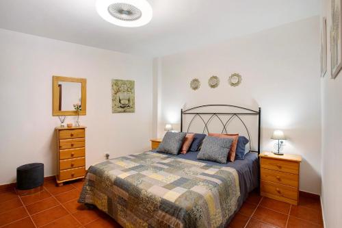 a bedroom with a bed and two dressers and a mirror at Mi refugio en La Jaca in Arico