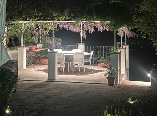 a patio with a table and chairs under a pergola at Villino Ca' Bianca, vicino ad Alba, NO ZANZARE, accessibile e con sollevatori aerei in Monteu Roero