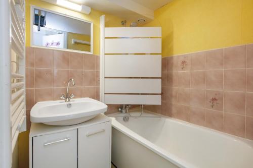 a bathroom with a sink and a toilet and a tub at Ty Dacoli - piscine et plage in Le Pouliguen