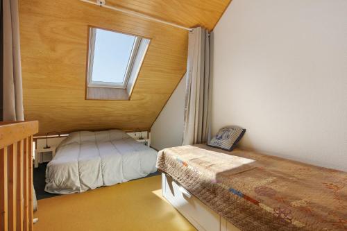 a small bedroom with a bed and a window at Ty Dacoli - piscine et plage in Le Pouliguen