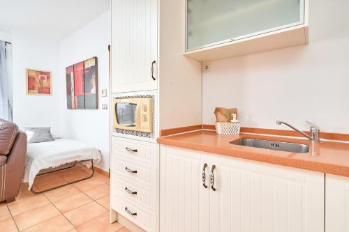 a kitchen with white cabinets and a sink at Costa Luxe Almuñecar in Almuñécar