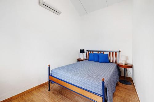 a bedroom with a blue bed in a white room at Casa Syrah in Palmela