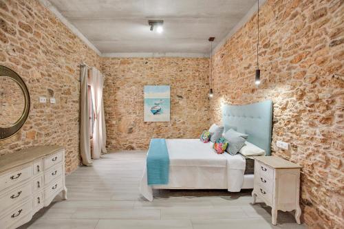 a bedroom with a bed and a stone wall at Casa Rural Sajoná in Tiscamanita