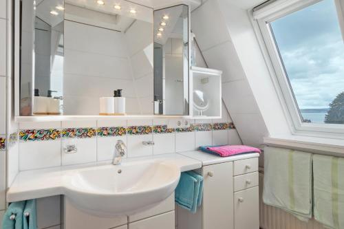 a bathroom with a sink and a window at Ferienappartement Pauli in Hagnau