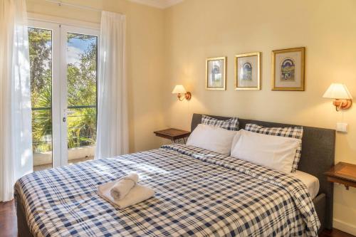 a bedroom with a bed with a blue and white checked blanket at Villa Echium T2 in Caniço