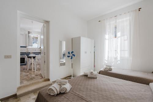 a white room with two beds and a kitchen at Sea Nest in Balestrate