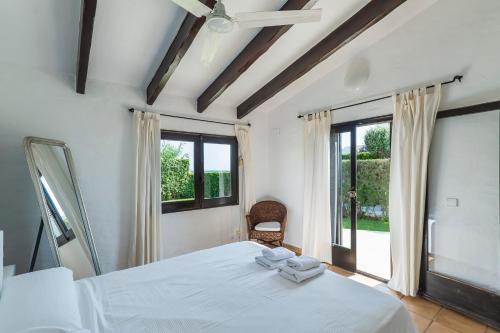 a bedroom with a white bed and a window at Villa Bini Andu in Binibeca