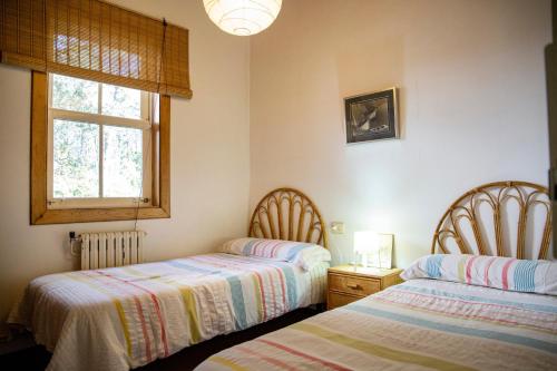 a bedroom with two beds and a window at Casa Con Encanto in Bueu