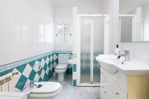 a white bathroom with a toilet and a sink at Casa Vesalia in Vinarós