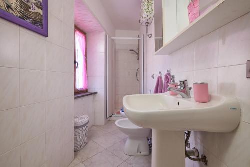 a white bathroom with a sink and a toilet at La Nicchia in Tirli