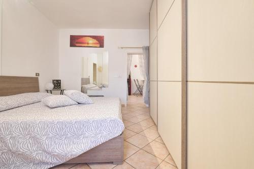 a white bedroom with a bed and a refrigerator at La Nicchia in Tirli