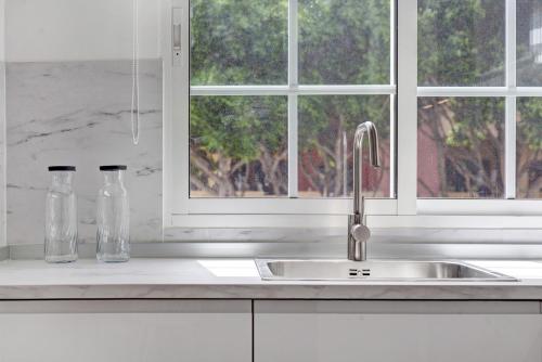 a kitchen counter with a sink and two glass bottles at Apartamento Puerto Playa in Puerto del Rosario