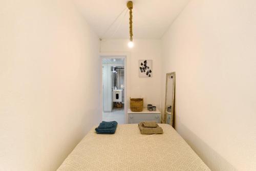 a bedroom with a bed and a white wall at Tróia Beach House in Carvalhal