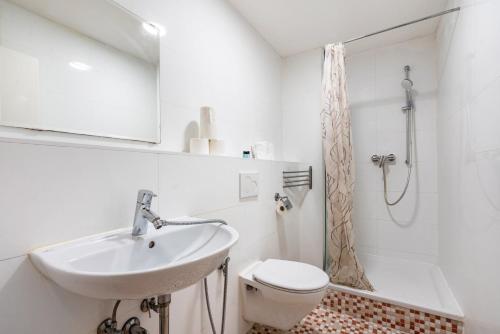 a white bathroom with a sink and a toilet at Aldars Urban Loft Suite No.8 in Munich