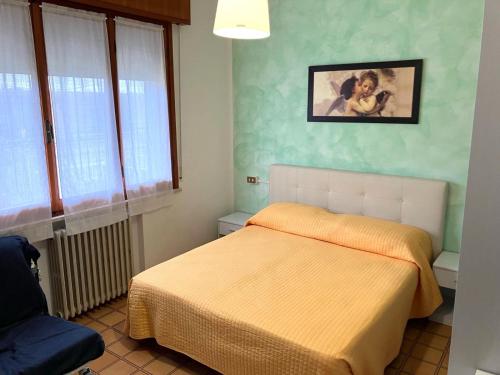 a bedroom with a bed and a picture on the wall at Sole Apartment in Rimini