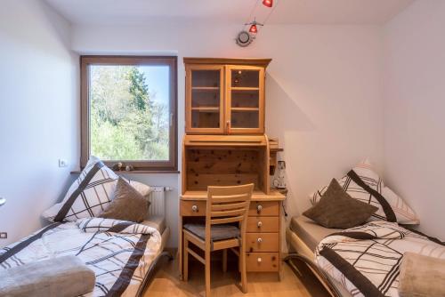 a room with two beds and a desk and a window at Apartment Schlernblick in Umes