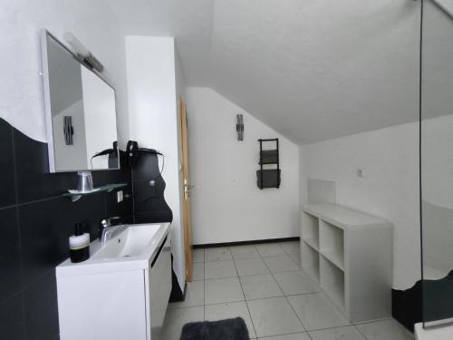 a white bathroom with a sink and a mirror at Ferienwohnung Andreas in St. Blasien