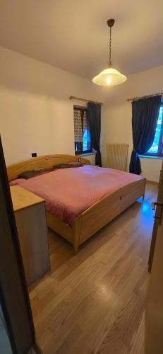 a bedroom with a large wooden bed in a room at La Locanda dei Nonni in Pozza di Fassa