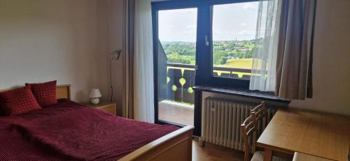 a bedroom with a bed and a large window at Fe-Wo Berg und See in Hauzenberg