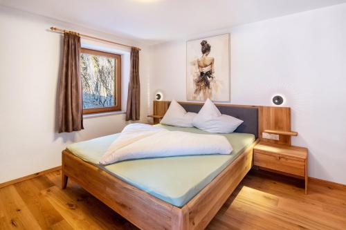 a bedroom with a bed with a wooden headboard at Pixnerhof - Ferienwohnung Gala in Kastelbell-Tschars
