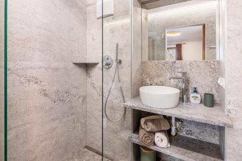a bathroom with a glass shower and a sink at Pixnerhof - Ferienwohnung Gala in Kastelbell-Tschars